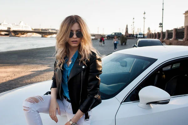 Красивая и стильная молодая блондинка. Портрет на заднем плане ее машины — стоковое фото