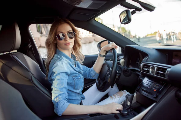 Junge attraktive Frau am Steuer ihres Autos. Porträt einer erfolgreichen Geschäftsfrau — Stockfoto