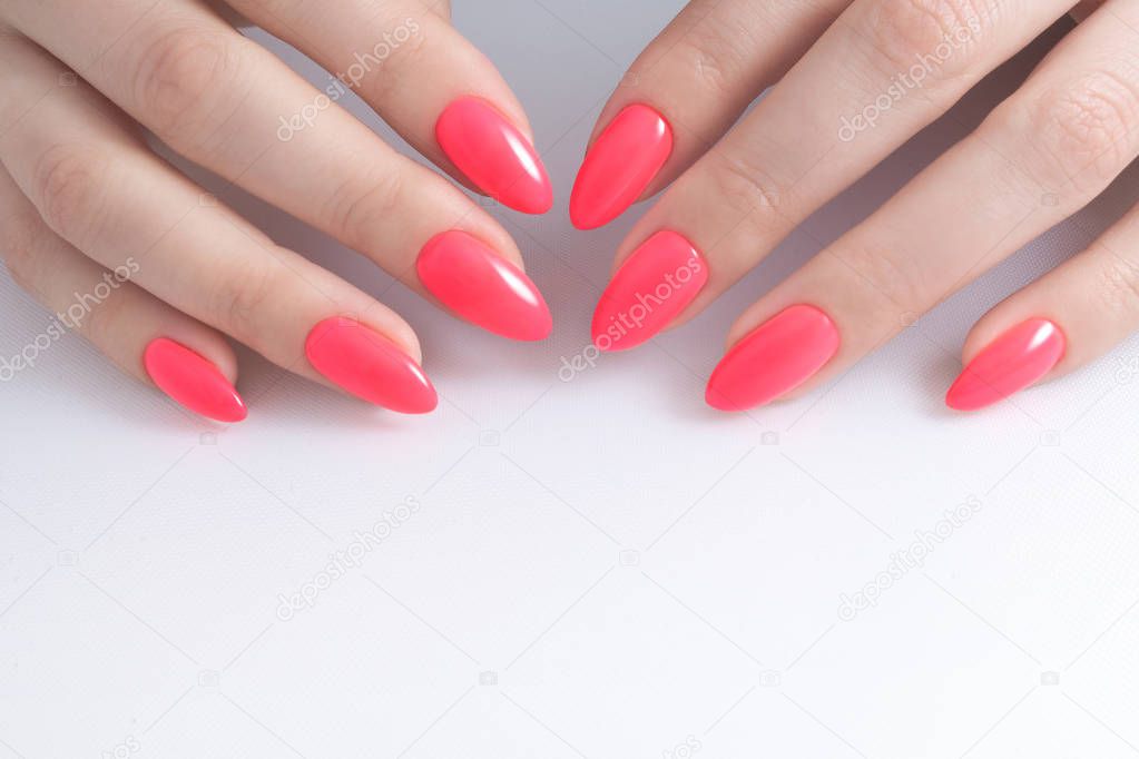 Women's manicure, on a white background. Nail Polish red coral color.