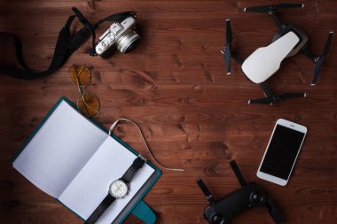 Modern gezgin, yaşam konsepti düzeni. Günlüğü, akıllı telefon, kamera ve drone vintage ahşap zemin üzerinde. Merkezi boşaltmak