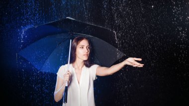 Genç kadın şemsiyesi altında. Yağmur koruma.