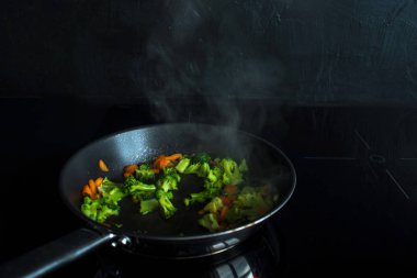 Brokoli ve havuç fry. Vejetaryen yemek. Pişirme işlemi.