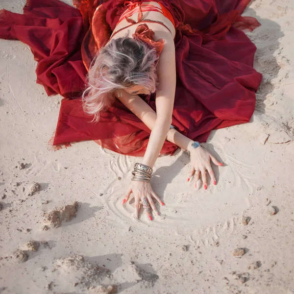 Danza oriental. Hermosa mujer sentada en la arena, manos con pulseras en la arena . —  Fotos de Stock