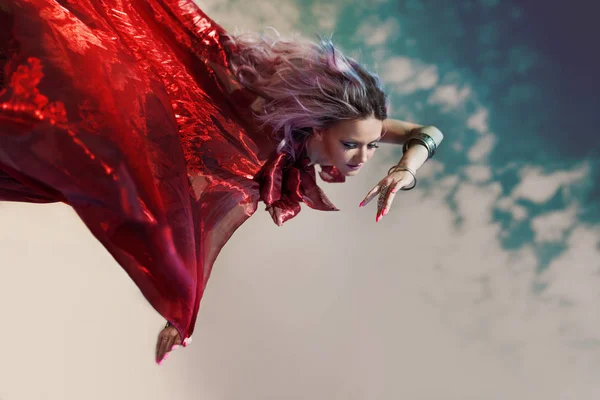 Fantastisk nymf flyger. Utmärkt porträtt av en flygande kvinna i en röd klänning — Stockfoto
