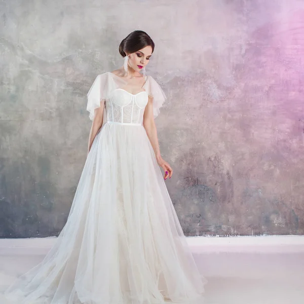 Schöne und stilvolle Braut im Hochzeitskleid im Studio — Stockfoto