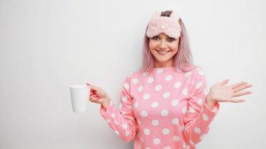 Mutlu genç kadın sabah kahve iç. Güzel kız pembe pijama ve sleepmask