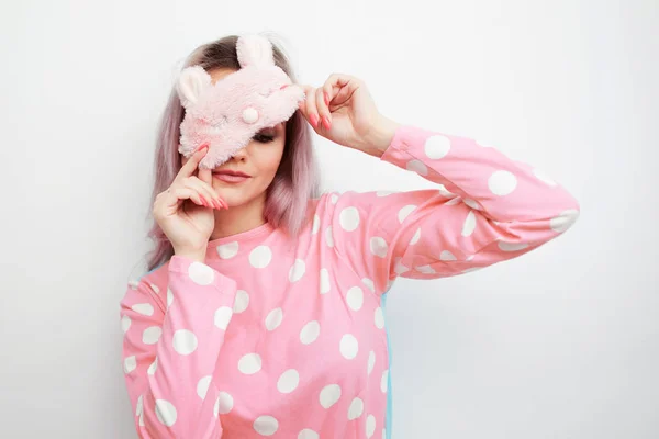 Красивая молодая блондинка в розовой пижаме и маска для сна на глазах — стоковое фото