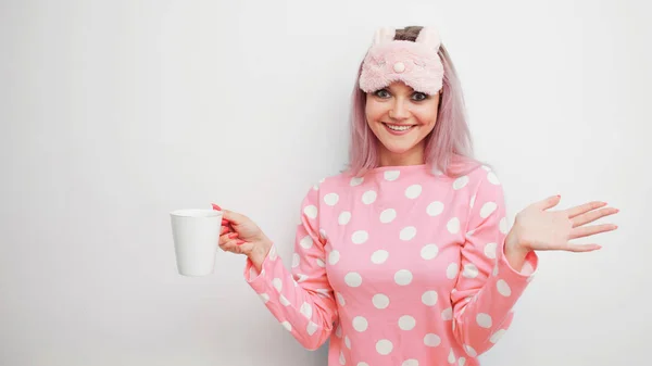 Ευτυχισμένη γυναίκα πίνει καφέ το πρωί. Όμορφο κορίτσι στο ροζ πιτζάμες και sleepmask — Φωτογραφία Αρχείου