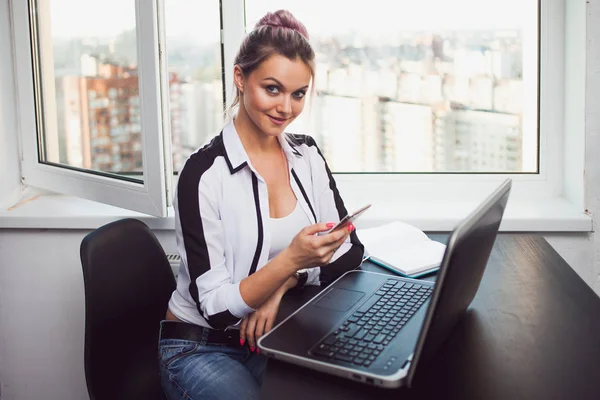 Young blonde working on a laptop. Girl in modern office — Stock Photo, Image