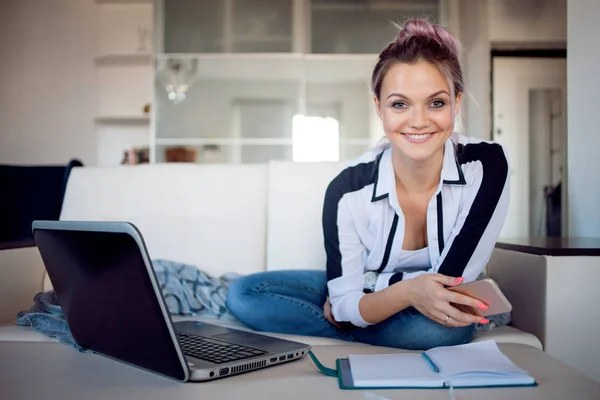 Happy freelancer works at home. Young woman with laptop on sofa. — Stock Photo, Image