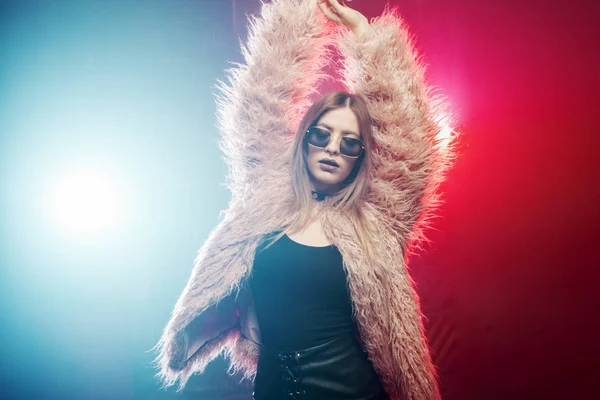 Trendy girl dancing in a fluffy pink coat — Stock Photo, Image