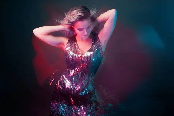 Mujer joven brillante y elegante bailando en el club, luz de color, efectos de movimiento — Foto de Stock