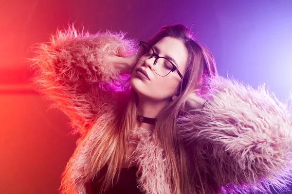 Trendy girl dancing in a fluffy pink coat — Stock Photo, Image