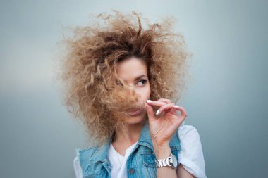 Gür saçlı genç çekici kadın. Denim yelek içinde güzel bir kızın portresi