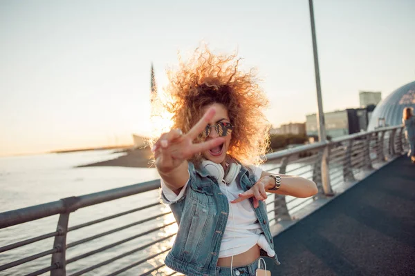 Jeune femme élégante avec des cheveux très luxuriants montrent signe de victoire — Photo