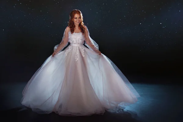 Mesés menyasszony egy gyönyörű ruhát a csillagok között. Fiatal gyönyörű nő, esküvői ruha, szoknya, széles fény — Stock Fotó