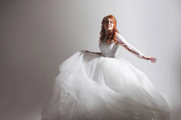 Táncoló fiatal nő esküvői ruha. Bájos menyasszony-ra könnyű háttér, árnyék — Stock Fotó