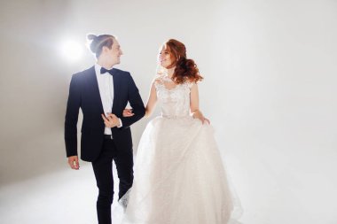 Gülen gelin ve damadın birbirlerine bakıyorlar, dans ve evli mutluluk ile atlamak.