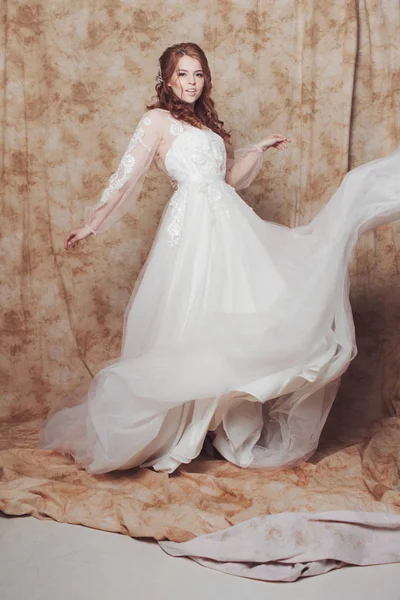 Beautiful and romantic bride in wedding dress with long sleeves. Young redheaded woman in wedding dress — Stock Photo, Image