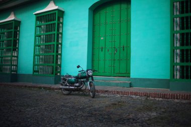 Motosiklet sokakta, yeşil evlerin zemin üzerine yeşil, renk etkisi