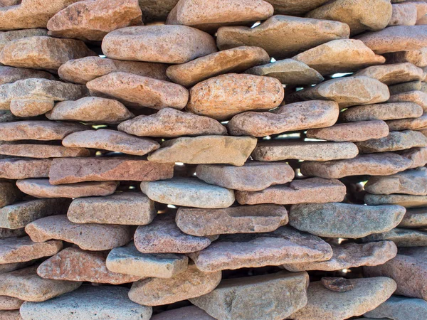 Textura de parede de seixos, parede é dobrada à mão de pedras planas — Fotografia de Stock