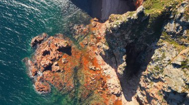 Denizde sarp kayalık uçurum dramatik görünümü. Mavi deniz ve kayalık sahil, dron fotoğraf şaşırtıcı görünümü