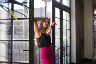 Büyük bir pencere yakınında güzel genç kadın.