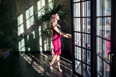 Büyük bir pencere yakınında güzel genç kadın.