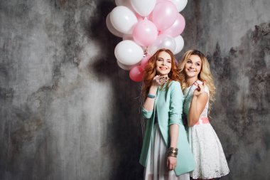 Sarışın ve Kızıl saçlı. İki genç kız partide büyüleyici. Balonlar ile mutlu ve neşeli kız.