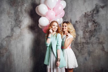 Sarışın ve Kızıl saçlı. İki genç kız partide büyüleyici. Balonlar ile mutlu ve neşeli kız.