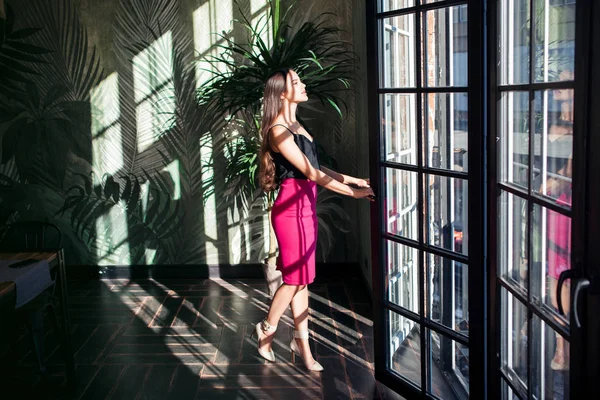 Büyük bir pencere yakınında güzel genç kadın.