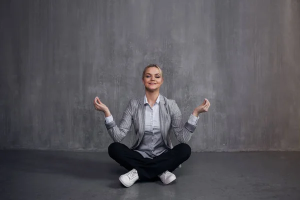 Mulher jovem em terno de negócios sentado em pose de lótus, restaurar a energia, meditar. Saúde e trabalho — Fotografia de Stock