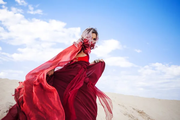 Vrouw in het rood. Weglopen van meisje in verbazingwekkende dieprode jurk. — Stockfoto