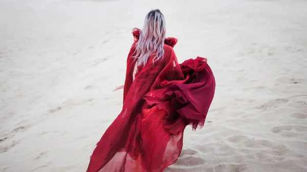 Kırmızılı kadın. Şaşırtıcı kırmızı elbiseli kız kaçmak. Arkadan görünüm — Stok fotoğraf