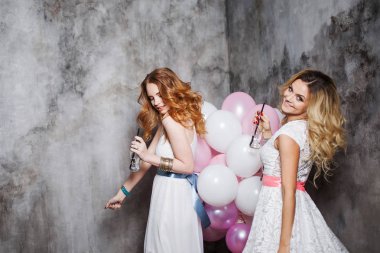 Sarışın ve Kızıl saçlı. İki genç kız partide büyüleyici. Balonlar ile mutlu ve neşeli kız.