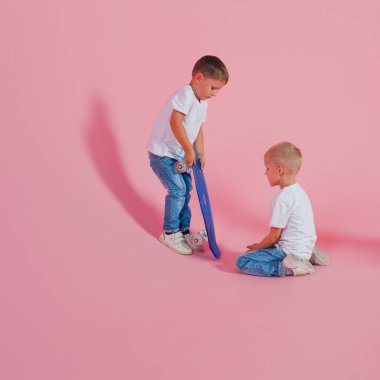 İki kardeş bir kaykay paylaşmak. bir kaykay ile küçük çocuk. Acemi patenci