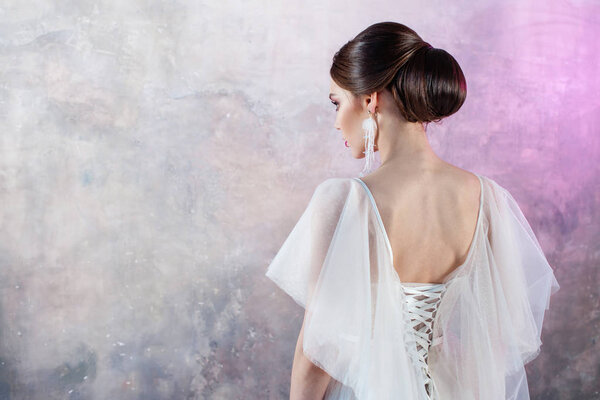 Portrait of a young elegant brunette bride with a stylish hairstyle.