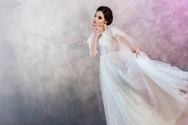 Retrato de uma jovem noiva morena elegante com um penteado elegante . — Fotografia de Stock