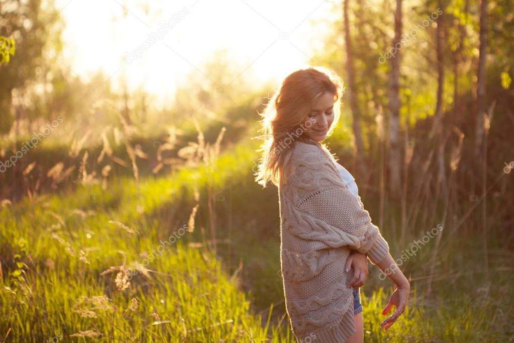 Cute charming girl in summer in the field. Young woman is happy and feels free outdoors