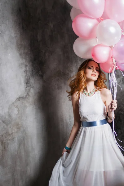Jovem loira encantadora em um vestido branco com balões rosa, na festa . — Fotografia de Stock
