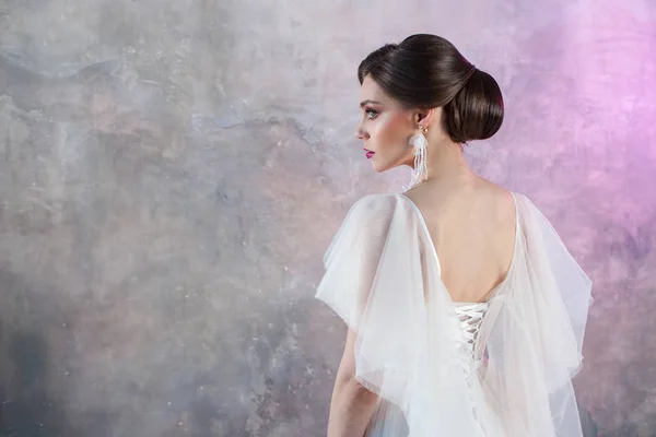 Retrato de uma jovem noiva morena elegante com um penteado elegante . — Fotografia de Stock