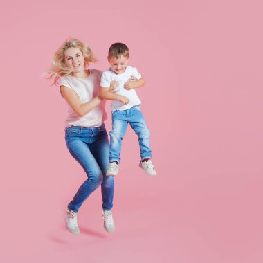 Genç oğlu ile pozitif Genç Anne. Atlama onun bebek çocuk ile güzel sarışın