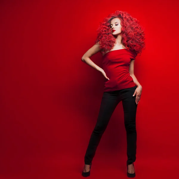 Retrato de una hermosa joven con el pelo rojo sobre fondo rojo —  Fotos de Stock