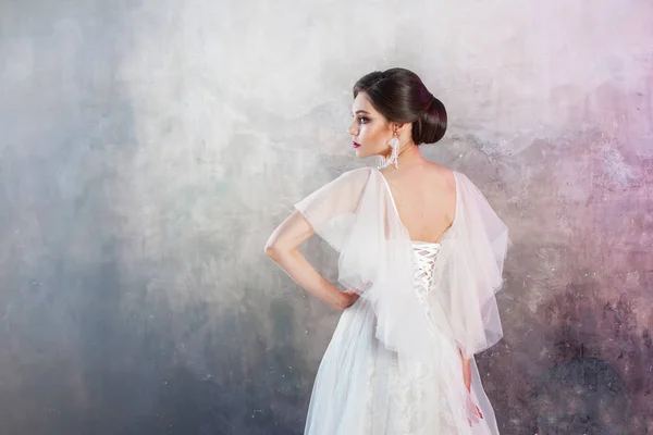 Vista posteriore di una giovane sposa bruna elegante con un'acconciatura elegante . — Foto Stock