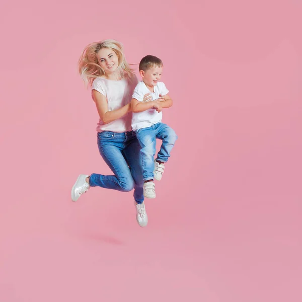 Una joven madre positiva con un hijo pequeño. Hermosa rubia con su bebé saltando — Foto de Stock
