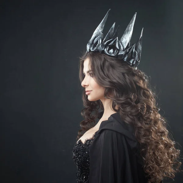 Portrait of a Gothic Princess. Beautiful young brunette woman in metal crown and black cloak. — Stock Photo, Image