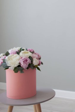 Hediyelik şapka kutusunda peonies şık buket. Işık gri arka plan üzerinde pembe kutu
