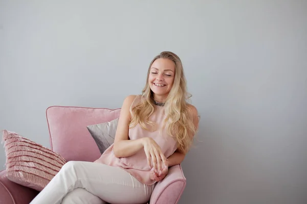 Joven mujer amigable sentada en una silla con un cuaderno en sus manos. Un buen compañero. . — Foto de Stock