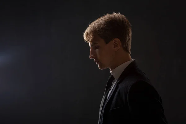 Siyah bir arka plan iş takım elbiseli Genç bir adamın profili. — Stok fotoğraf