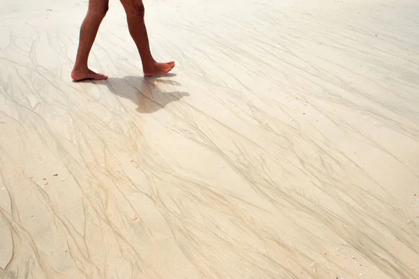 La textura de la arena mojada, surf. Hombre caminando en la playa — Foto de Stock